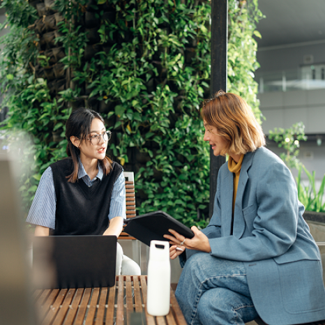 Two colleagues reviewing information on a tablet in a modern office